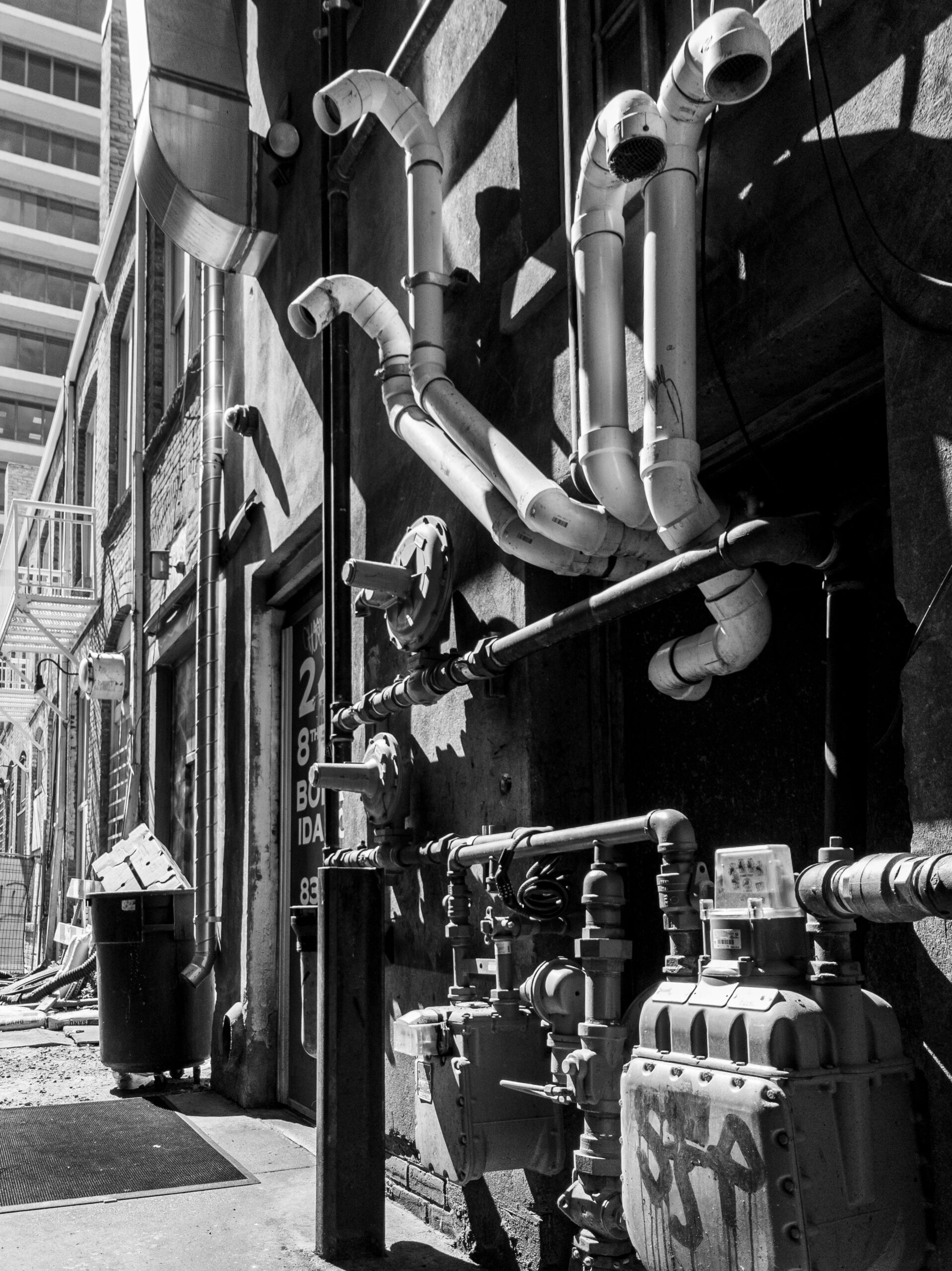 Monochrome view of an industrial alley with pipes and machinery in Boise, Idaho.